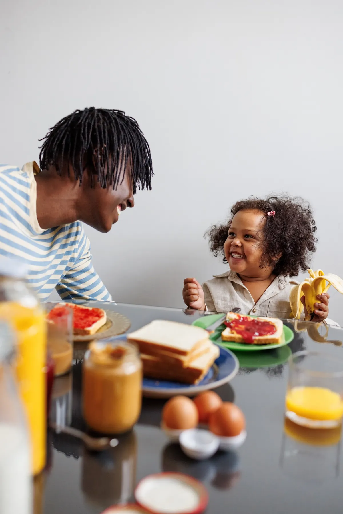 A family laughing over breakfast at the kitchen table