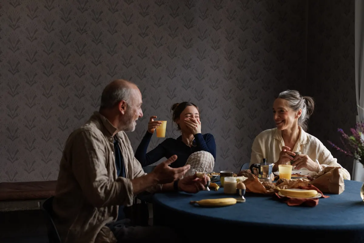 Three generations laughing over breakfast at home
