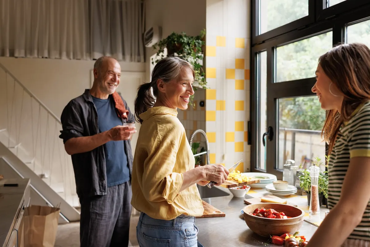 An older couple cooking together in a sunny kitchen