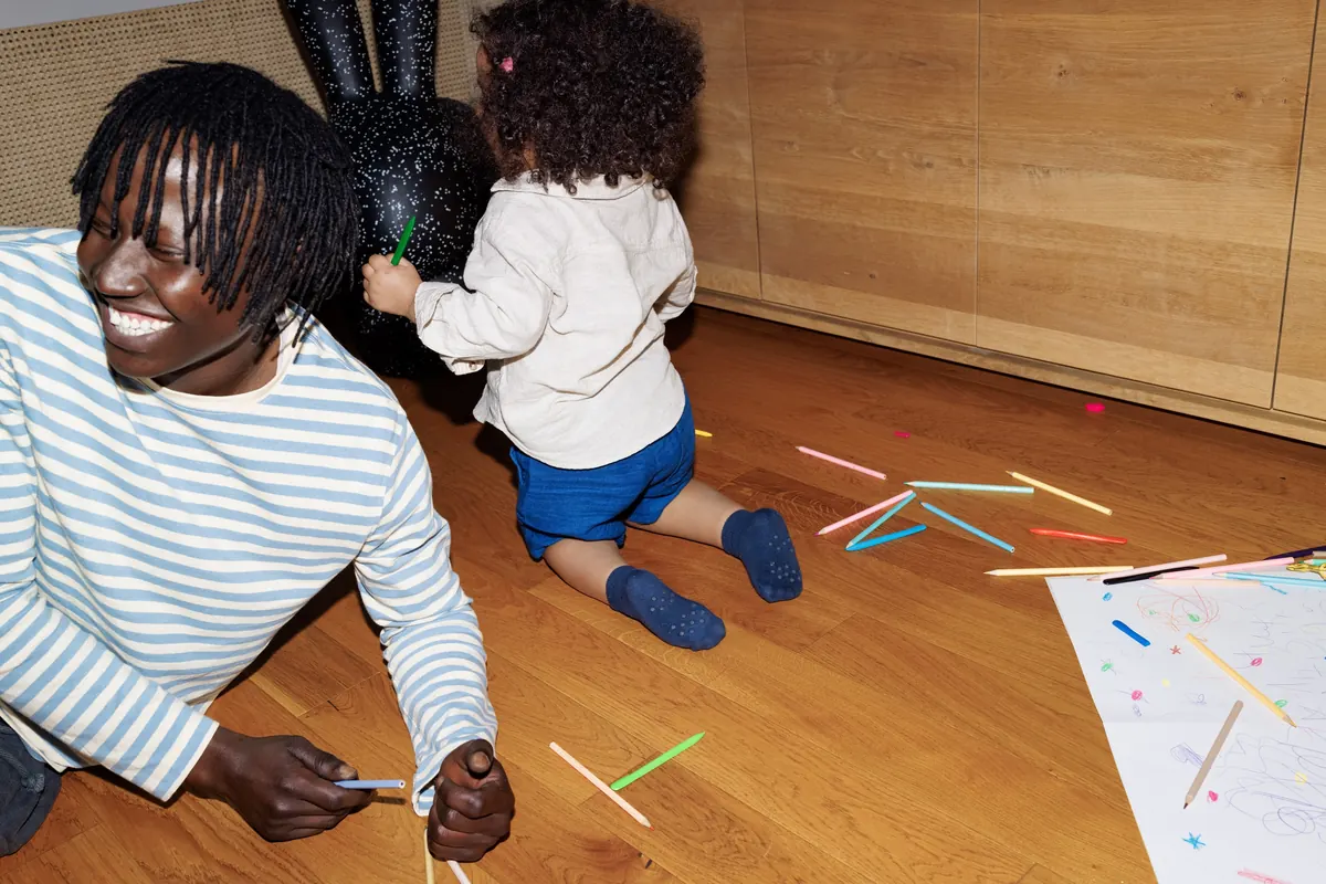 A father and daughter playing on the living room floor